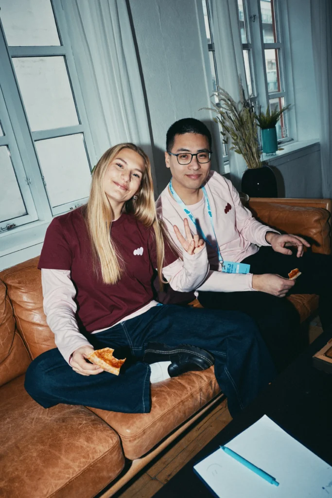 To frivillige fra Jobpatruljen holder pause og hygger sig sammen med pizza.